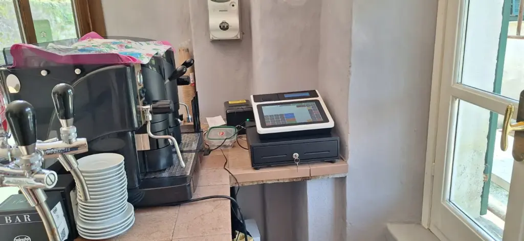 Cassa touch con cassetto installata nel bar accanto alla macchina del caffè