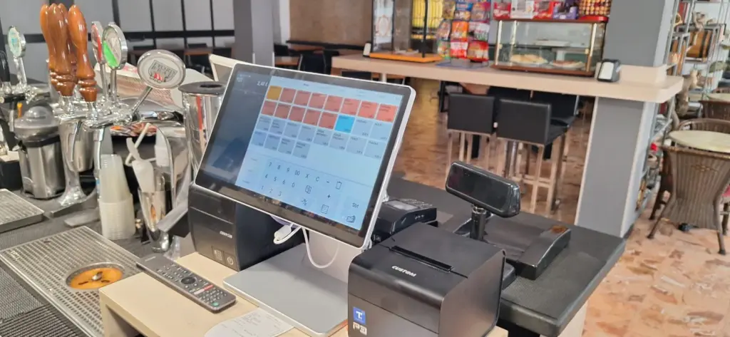 Postazione cassa touch con stampante e display cliente al bancone di un bar